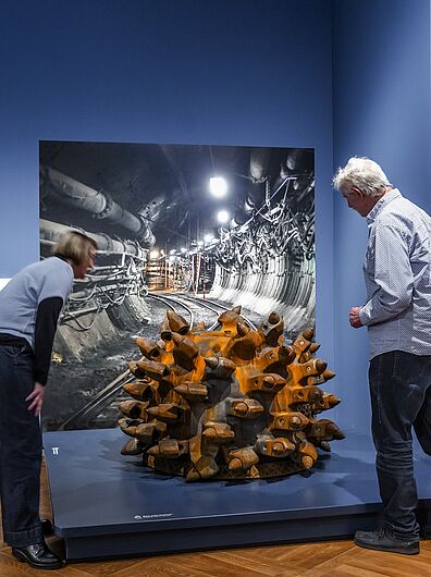 In der Ausstellung „Objekte. Geschichte. Geschichten. Blick in die Sammlung” Menschen stehen in einer Ausstellung