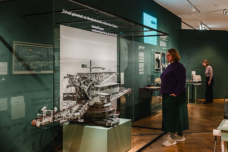 In der Ausstellung „Natur und deutsche Geschichte. Glaube – Biologie – Macht” Menschen stehen in einer Ausstellung