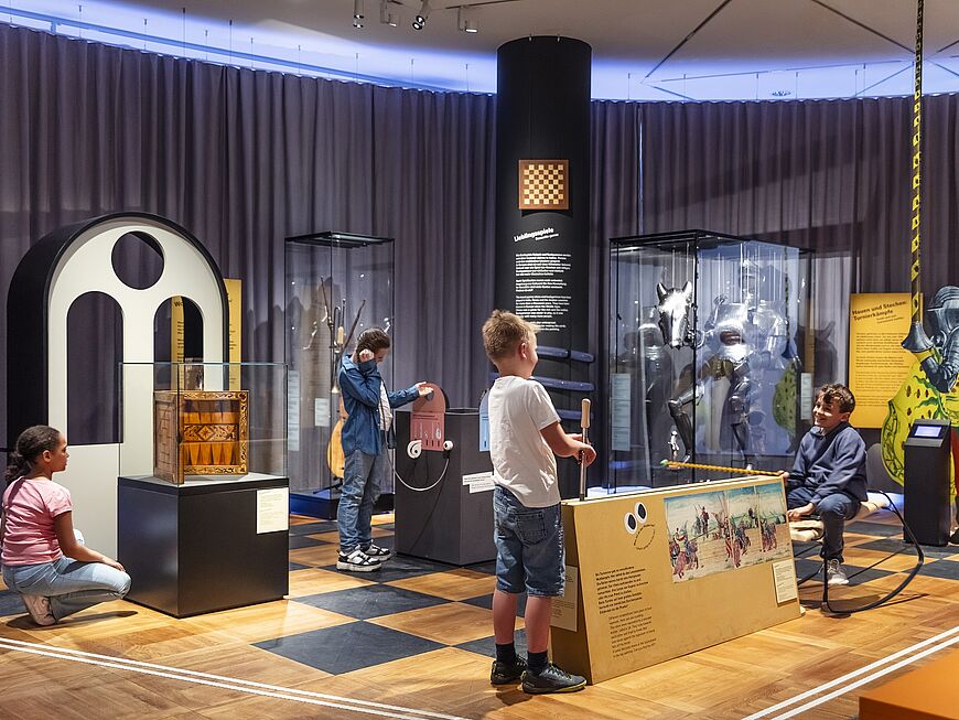 Kinder, die die Ausstellung besuchen, beschäftigen sich mit verschiedenen Ausstellungsobjekten.