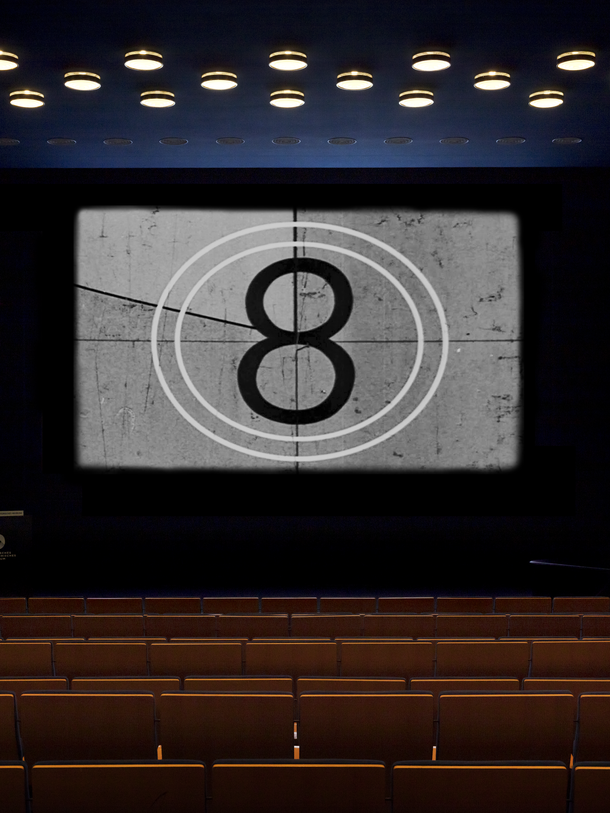 Platzhalter Kinoprogramm 1 Ein leerer Kinosaal mit einer 8 auf der Leinwand.