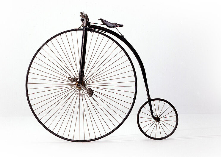 Hochrad, um 1890. Hochräder waren seit 1870 im Bürgertum sehr beliebt. Nach 1885 setzte sich das einfacher zu fahrende und damit sicherere Niederrad mit zwei gleich großen Rädern und Kettenantrieb übers Hinterrad durch. (Inv.Nr. Pro 60/35)
