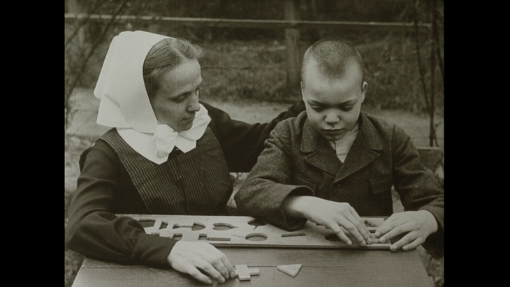 Eine Frau und ein Junge spielen mit Objekten.