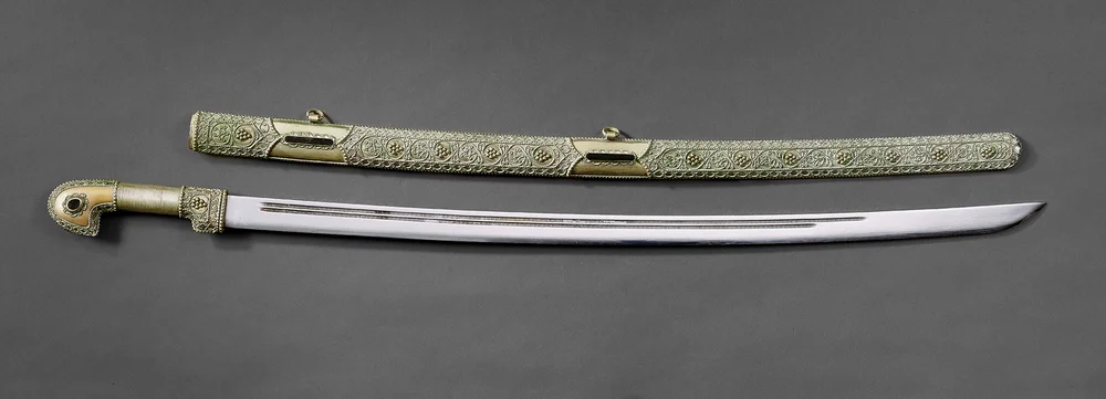 The picture shows a Cossack saber with a typically curved blade and its accompanying scabbard